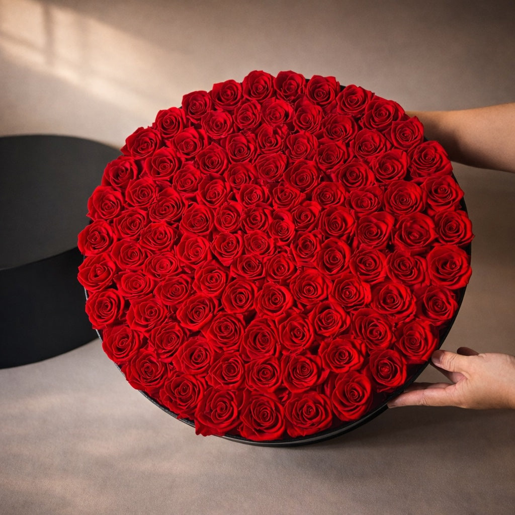 Round black box filled with 99 red preserved roses 