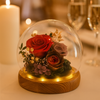Decorative glass dome with preserved flowers on a wooden base, blurred background