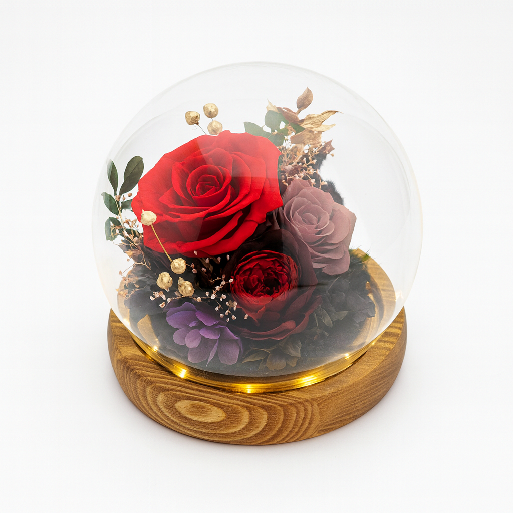 Glass dome with preserved red and purple roses on a wooden base against a white background