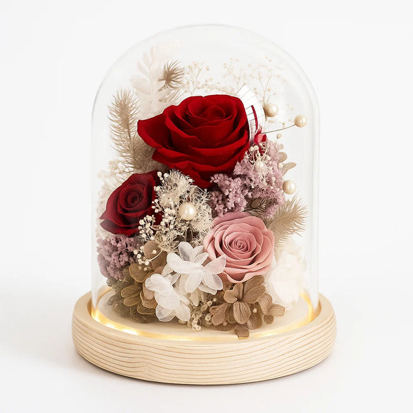 Decorative glass dome with red and pink roses and flowers on a white background