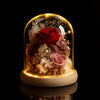 Decorative lamp with preserved flowers under a glass dome on a black background
