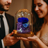 Couple holding a glass dome with blue and purple preserved flowers