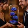 Man and woman holding a glass dome with blue roses