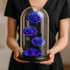 Person holding a glass dome with blue roses inside