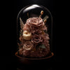 Glass dome with preserved flowers on a black background