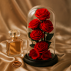 Glass dome with red preserved roses on a beige fabric background