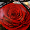 Red preserved rose in a clear dome with a black ribbon in the background