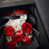 Bouquet of red preserved roses with white accents in a black box