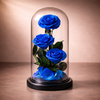 Three blue preserved roses inside a glass dome